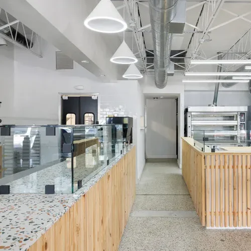 beautiful kitchen Modern interior of a cafe with glass display cases and wooden accents.