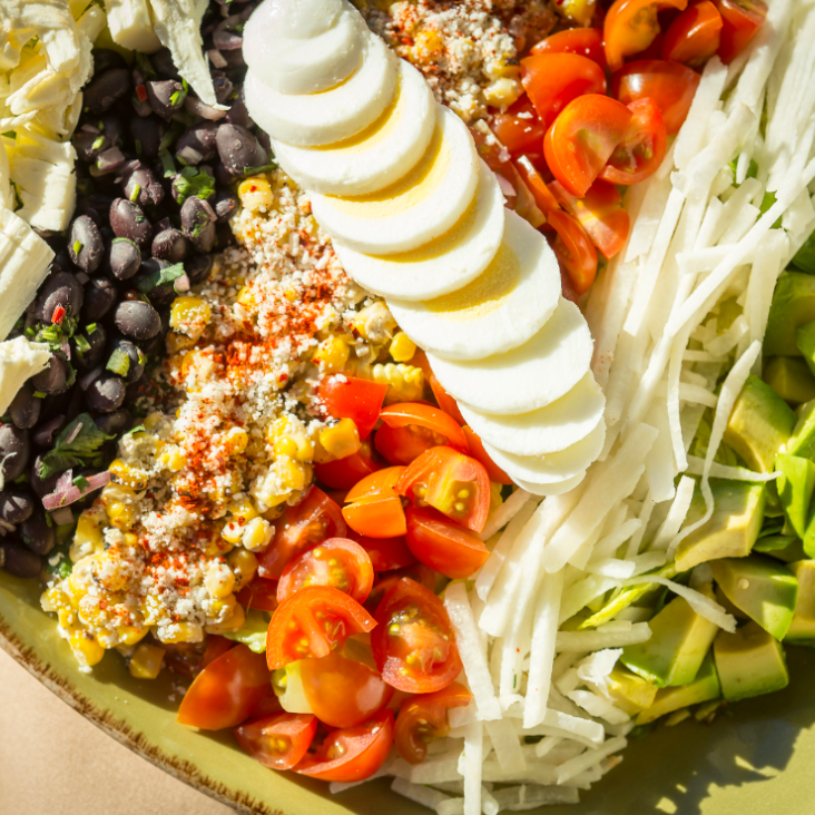 MexiCali Cobb Salad A colorful salad with sliced eggs, tomatoes, black beans, and corn.